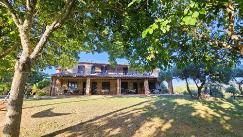 una grande casa con un ampio cortile alberato di Pian della Bandina a Città della Pieve