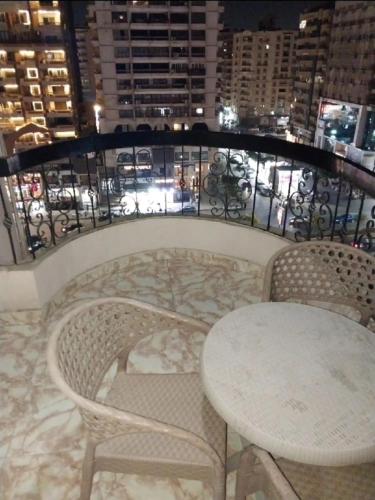 a balcony with a table and chairs and a view of a city at شقة مفروشة للايجار عباس الرئيسي in Cairo