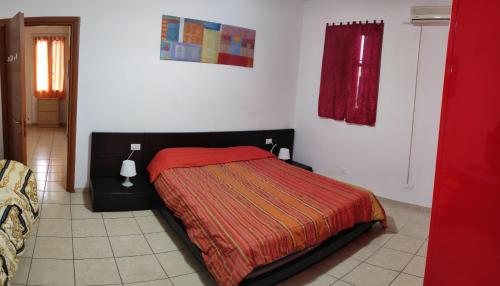 een slaapkamer met een bed met een rode deken bij Appartamento bilocale in Milaan