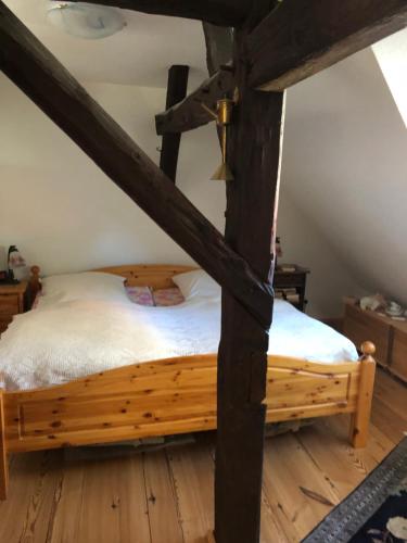 a wooden bed in a room with wooden floors at Romantische Ferienwohnung im historischen Stadtkern Jüterbog in Jüterbog
