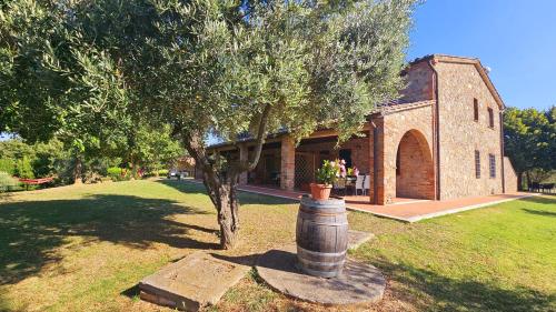 a church with a tree in front of a building at Pian della Bandina in Città della Pieve