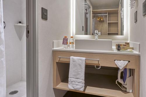 bagno con lavandino e specchio di City Express Suites by Marriott Silao Aeropuerto a Silao