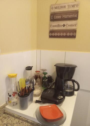 a kitchen counter with a coffee maker and utensils at Golden Express Flat B-119 - Conforto e lazer para toda Família in Caldas Novas