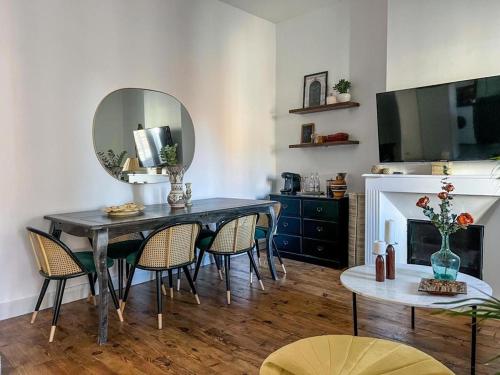 a dining room with a table with chairs and a mirror at Spacieux et lumineux T3, centre TARBES in Tarbes