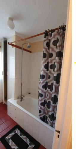 a bathroom with a bath tub with a cow shower curtain at EMBASSY COURT SERVICED APARTMENTS in Nairobi
