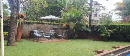 a patio with a table and chairs and an umbrella at EMBASSY COURT SERVICED APARTMENTS in Nairobi