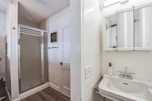 a white bathroom with a sink and a shower at Sunrise Cove - Oceanfront Bliss Luxury Beach Retreat in East Haven