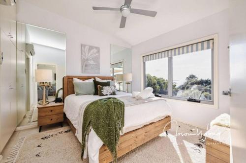 ein Schlafzimmer mit einem großen Bett und einem Fenster in der Unterkunft The Salty Seagull – ocean-view luxe! in Encounter Bay