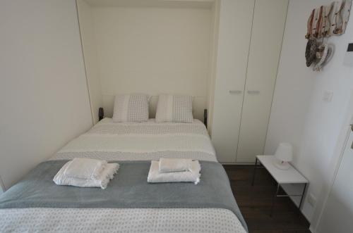 2 camas en una habitación blanca con toallas en An's seaview Middelkerke en Middelkerke