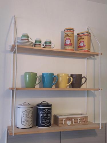 a shelf filled with coffee cups and bowls at Apartman Teo in Lukavica