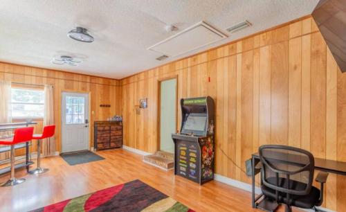 a room with a video game machine and red chairs at Golden Isles Lrge Home- Huge Pool, Hot Tub, Game Rm in Brunswick