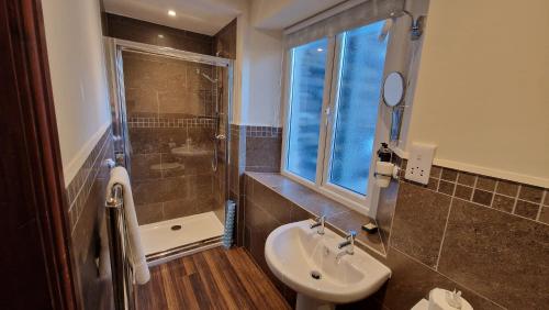 a bathroom with a sink and a shower at Ambleside Manor - Vegetarian B&B in Ambleside