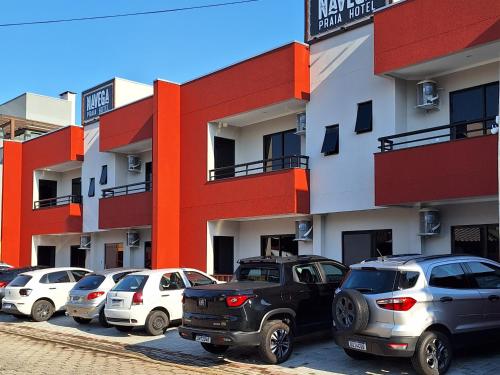 a parking lot with cars parked in front of a building at NAVEGA PRAIA HOTEL in Navegantes