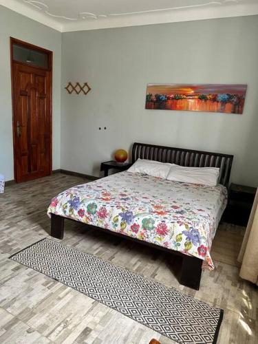 a bedroom with a bed with a colorful comforter at Green Haven in Entebbe