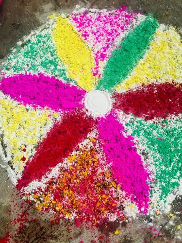 a colorful umbrella covered in colorful sprinkles on the ground at Sunrise Hotel in Bharatpur