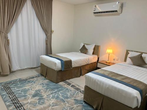 a hotel room with two beds and a television at اجنحة بيادر السكنية in Medina