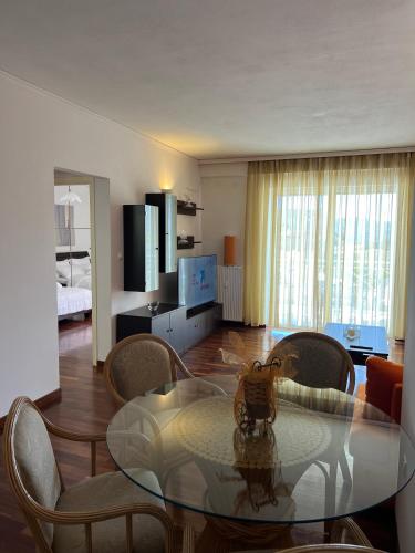 a living room with a glass table and chairs at Machi's Apartment in Markopoulo