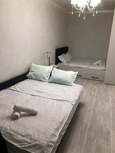1 Schlafzimmer mit 2 Betten und einem Kronleuchter in der Unterkunft Lux апартаменты ЖК 7я in Astana