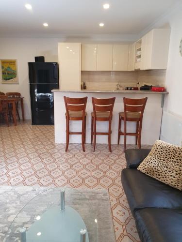 a living room with a couch and a kitchen at Exceptional Studio Apartment in Glenroy