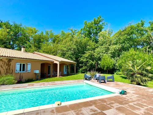 une maison avec une piscine dans une cour dans l'établissement Caporizon - Villa Puy d'Aiguillon- Piscine - 6 personnes, 