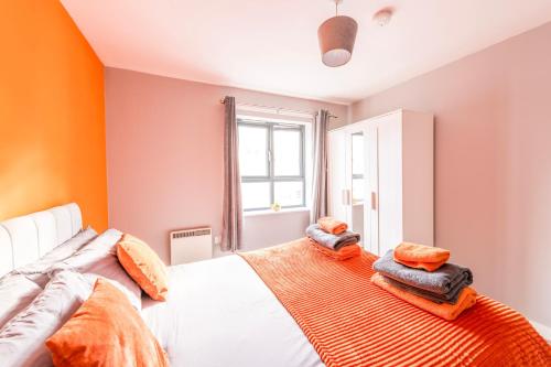 1 dormitorio con paredes de color naranja y 1 cama con almohadas de color naranja en PRIME LOCATION - City Center Apartment, en Bristol