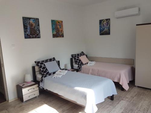 a room with two beds and two pictures on the wall at Apartament Angelo in Sosnowiec
