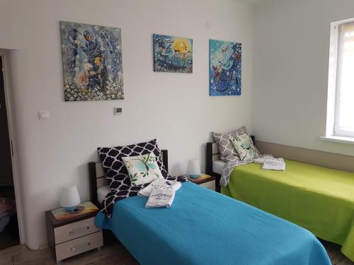a room with two beds and paintings on the wall at Apartament Angelo in Sosnowiec