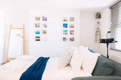 Habitación blanca con cama con almohadas blancas en *Central Brighton Modern Studio*, en Brighton & Hove