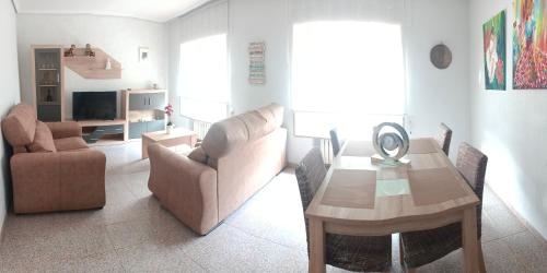 a living room with a couch and a table and chairs at Tu Apartamento Ideal in Ponferrada