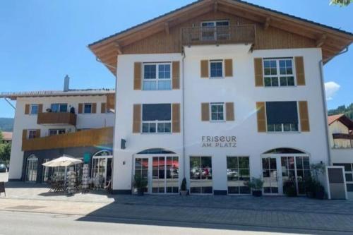 a large white building with a wooden roof at Maisonette Wohnung am Tegernsee in Bad Wiessee