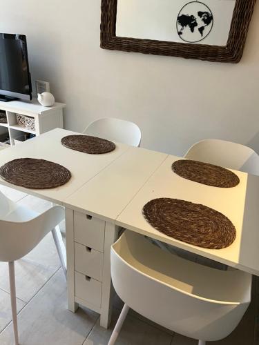 a white table with four brown cookies on it at Duinenzicht II De Haan in De Haan