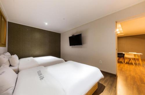 a bedroom with two beds and a flat screen tv at Daesan Hotel in Seosan