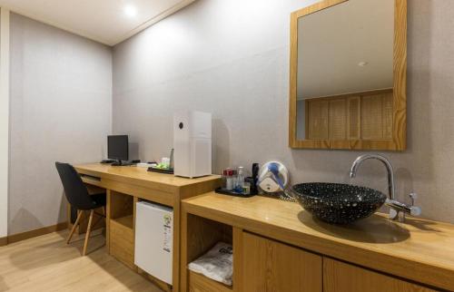 a bathroom with a sink and a mirror at Daesan Hotel in Seosan