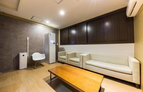 a living room with a couch and a coffee table at Daesan Hotel in Seosan