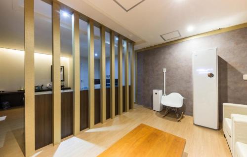 a living room with a table and a white chair at Daesan Hotel in Seosan