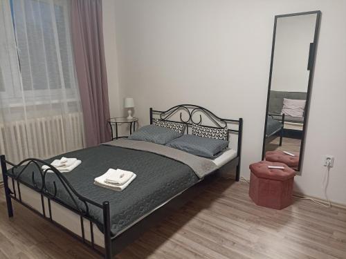 a bedroom with a bed with two towels on it at Apartmán Rose in Ostopovice