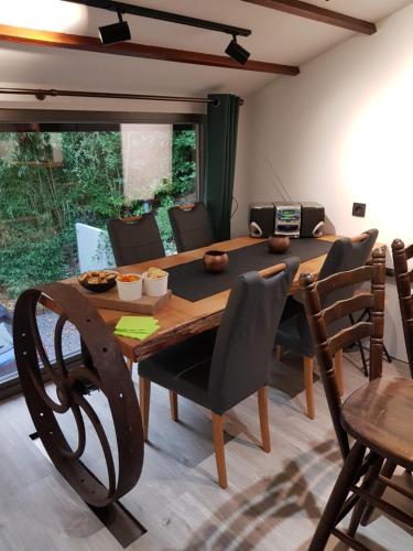 a dining room with a wooden table and chairs at Gite Au chalet de Mélines 