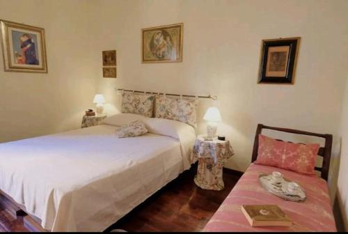 een slaapkamer met 2 bedden en 2 tafels met lampen bij Appartamento Mira in Lucca