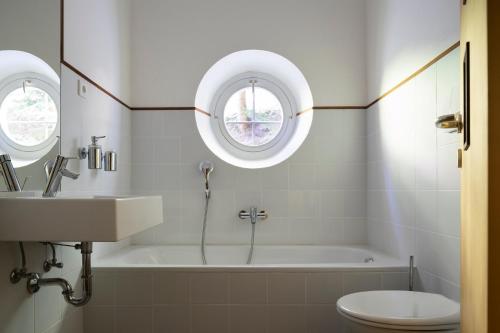 een badkamer met een bad, een wastafel en een toilet bij Landhaus Leonhard in Egna