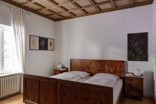 een slaapkamer met een groot houten bed in een kamer bij Landhaus Leonhard in Egna