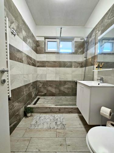 een badkamer met een douche, een wastafel en een toilet bij Sunrise Residence in Mamaia Nord – Năvodari