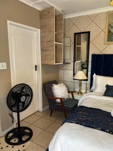 a bedroom with a bed and a chair and a mirror at 17 Byvanger Luxury Home Deluxe Queen Suite Room 1 in Centurion