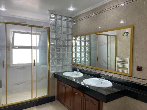 a bathroom with two sinks and a large mirror at Luxury Villa at Ain-Diab in Casablanca