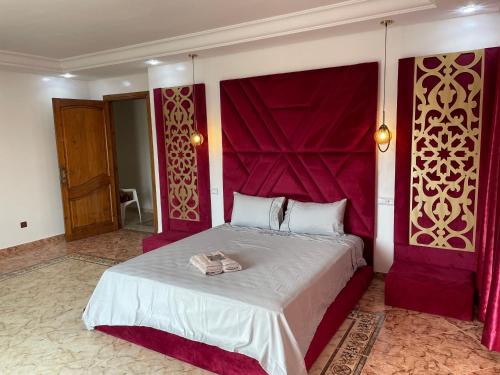 una camera con un grande letto con testiera rossa di Luxury Villa at Ain-Diab a Casablanca