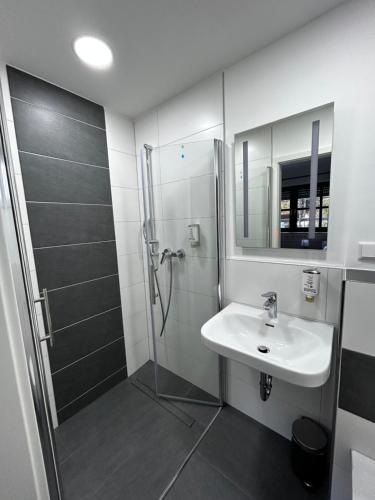 a bathroom with a sink and a shower at Olymp Wettenberg - Monteurzimmer in Launsbach