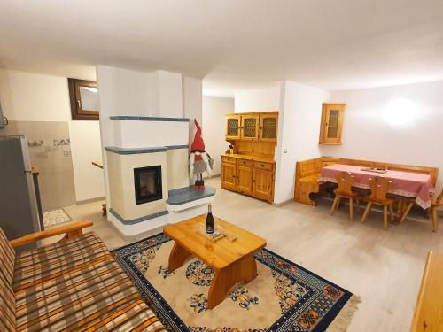 - un salon avec un canapé, une table et une cheminée dans l'établissement Il Rifugio dello Gnomo - Alpine Stay Apartments, à Panchià