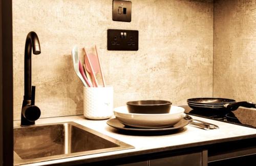 a kitchen with a sink and two pans and utensils at Modern 1-Bed Studio 4D Close to Royal Infirmary & DMU in Leicester