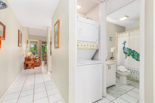 a white bathroom with a toilet and a hallway at Ilima West Kuilima Estates 18 At Turtle Bay in Kahuku