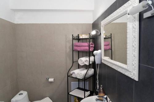 a bathroom with a towel rack and a mirror at Uno Apartment 2 in Livadia