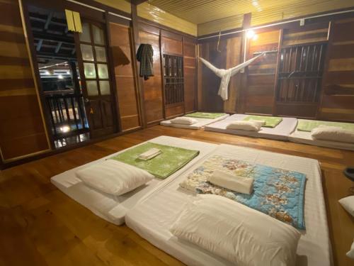 a room with three beds in a room with a meditation room at Hồng Gấm Homestay in Bak Kan